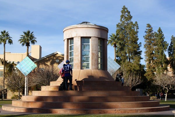 Late afternoon shadows are cast over students taking a break on the Hayden Lawn at the Tempe campus Tuesday. (Photo by Cameron Tattle)