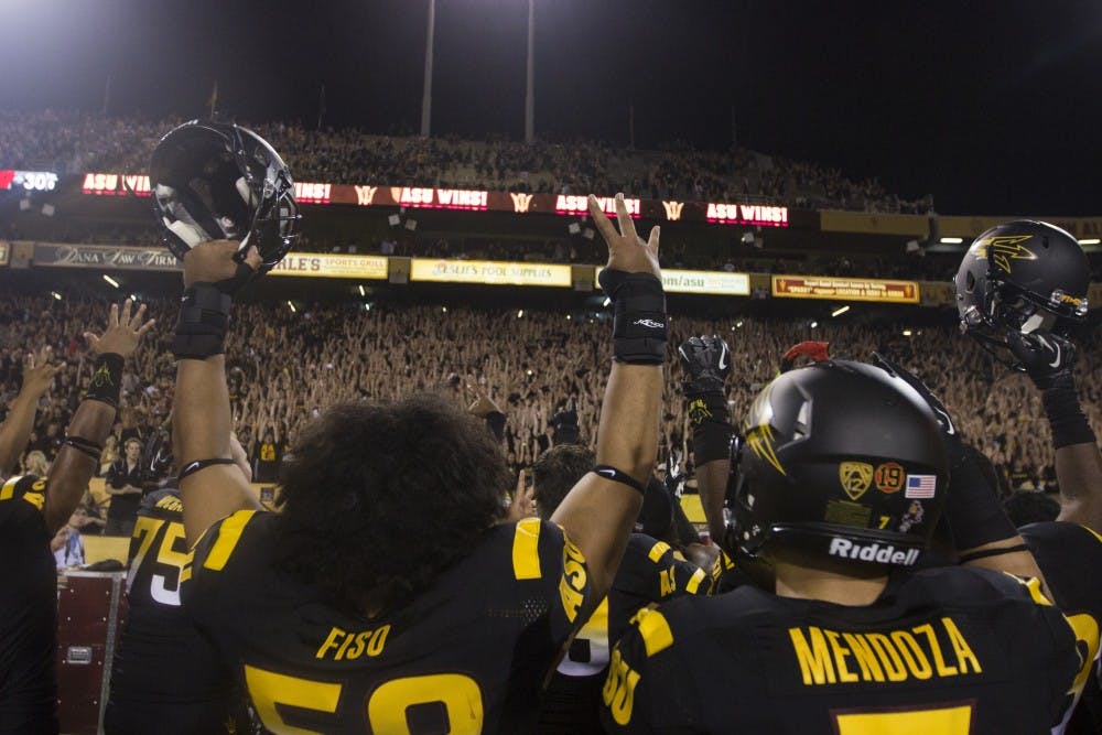 Redshirt freshman linebacker Salamo Fiso and redshirt freshman linebacker Carlos Mendoza raise their arms up to the fans after their victory over Wisconsin. ASU defeated Wisconsin 32-30 on Saturday. (Photo by Dominic Valente)  
