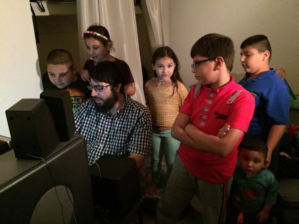 Riad Sbai,&nbsp;ASU alum and&nbsp;founder and president of PCs for Refugees,&nbsp;shows a family how to use new programs on their donated computer.