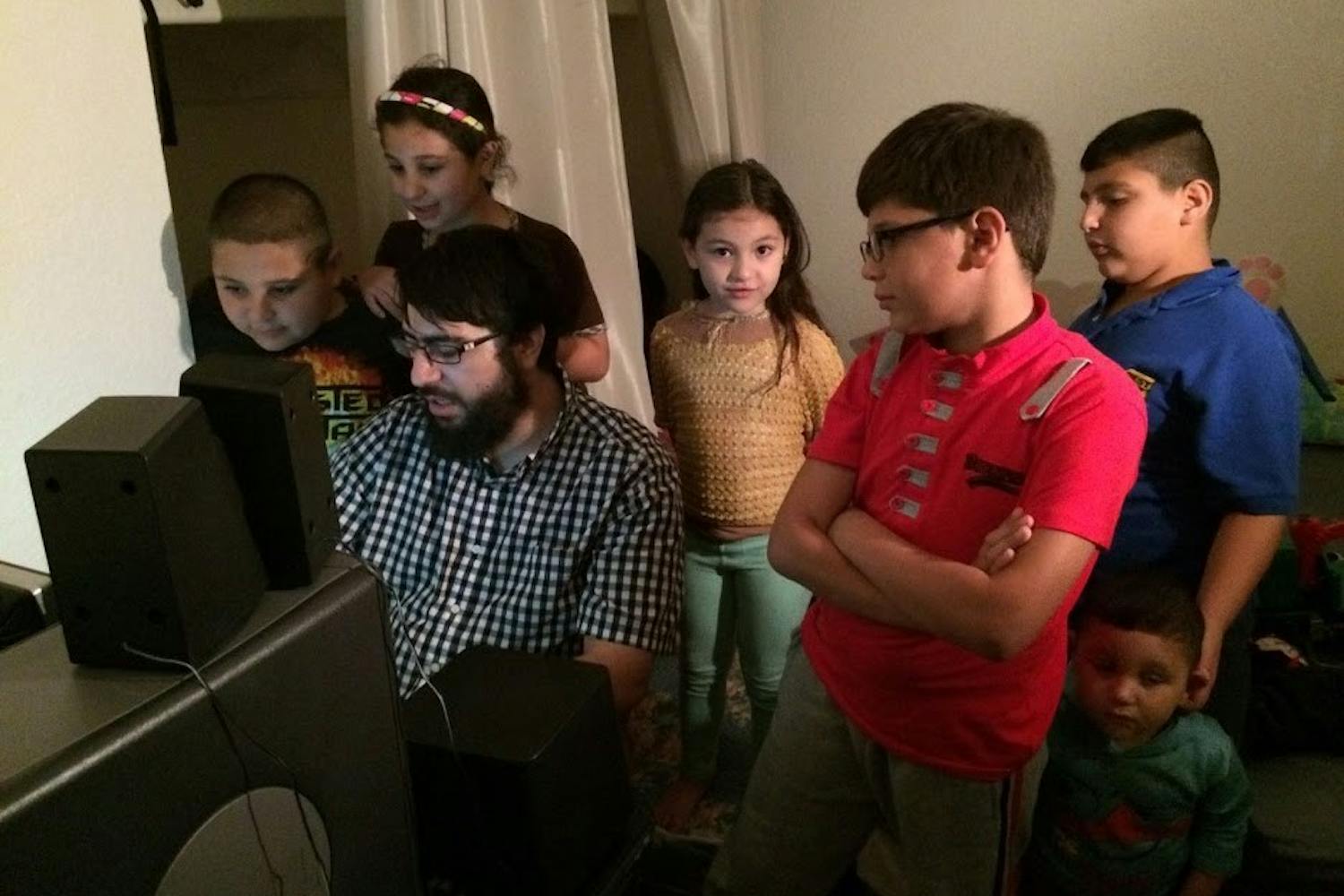 Riad Sbai,&nbsp;ASU alum and&nbsp;founder and president of PCs for Refugees,&nbsp;shows a family how to use new programs on their donated computer.