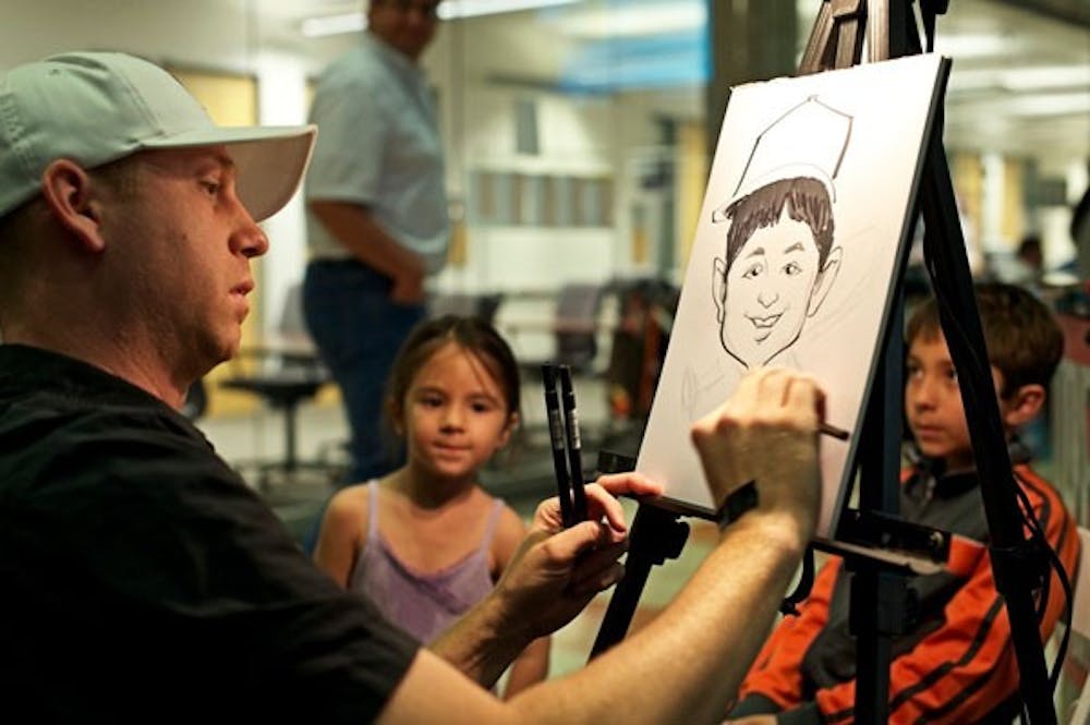 FIRST FRIDAY: A local artist creates children's caricatures during April's First Friday in the University Center on ASU's downtown campus. (Photo by Michael Arellano)