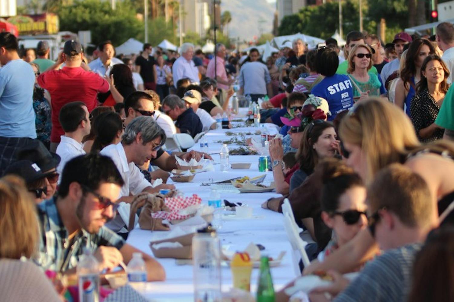 Phoenicians sit down to eat at Feast on the Street. Downtown Phoenix's feast on the street featured a mile and a half long table that stretched from Margaret T. Hance Park to ASU's downtown phoenix campus. (Photo by Dominic Valente)