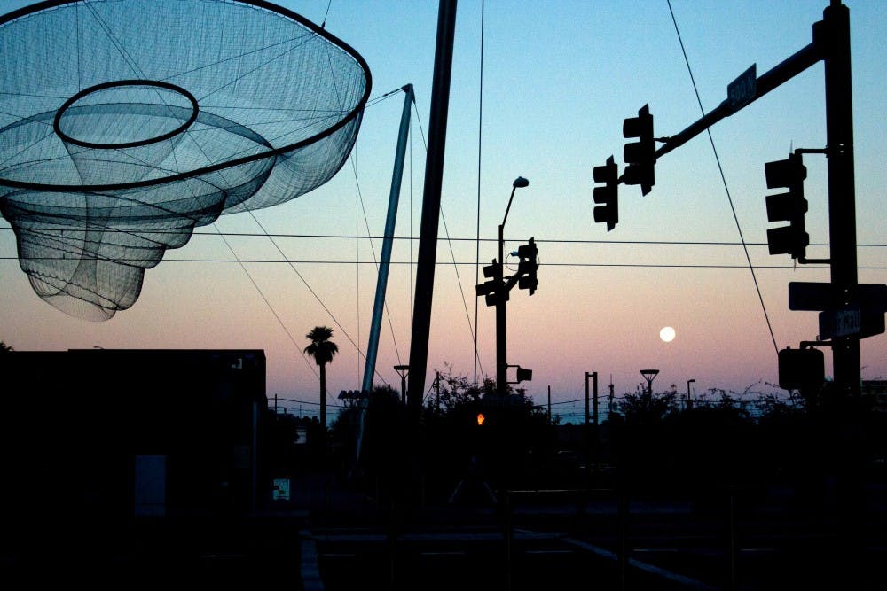 LOSING LIGHT: As the sun sets over ASU's Downtown campus the moon follows closely behind. (Photo by Lisa Bartoli)