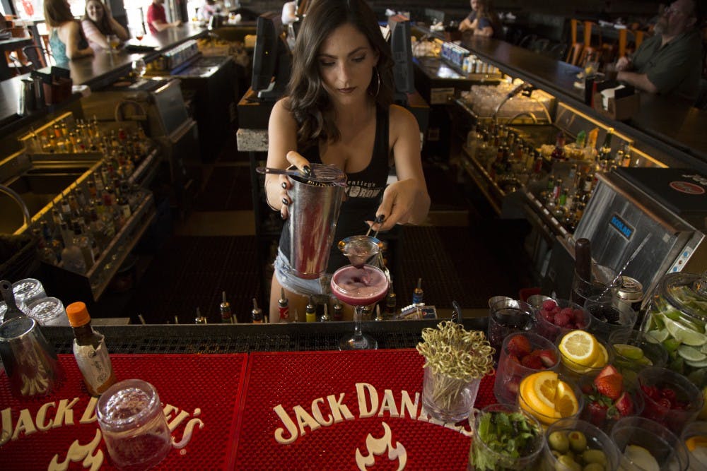 Bartender Bridget Davis, 23, makes a drink for a  customer at Whiskey Row on Thursday, April 7, 2016, on Mill Avenue in Tempe. 