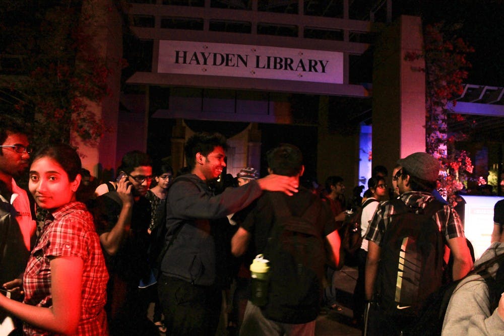 Students gather outside Hayden Library after a fire alarm went o