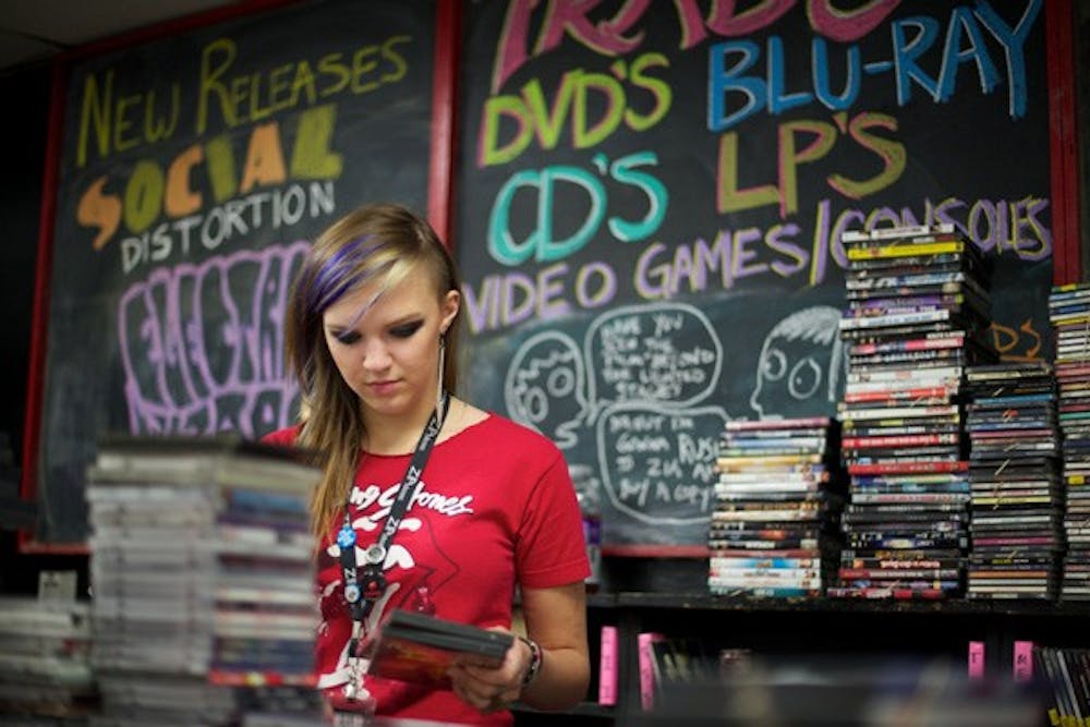 GOING STRONG: Rebecca Rice, an employee at Zia Records, sorts through CD's received in the store's used music collection.Opened in 1981, Zia Records continues to enjoy strong sales well into the digital-music age of the 21st century. (Photo by Michael Arellano)