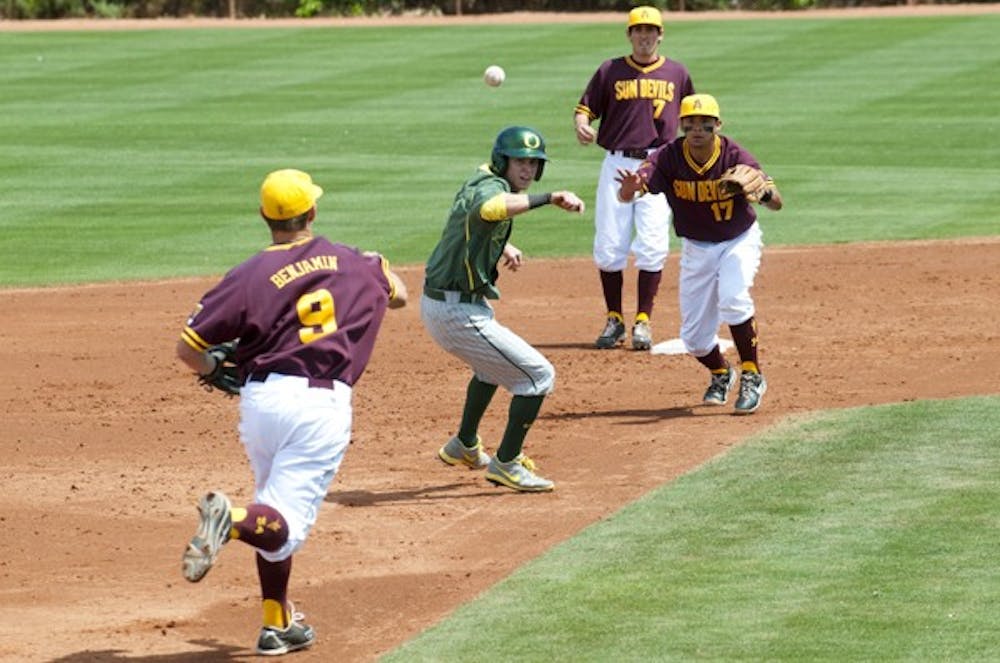 An Oregon baserunner ducks underneath a throw from junior infielder Michael Benjamin to freshman Drew Stankiewicz. The ASU baseball loss the series finale to the Ducks Sunday. (Photo by Molly J. Smith)