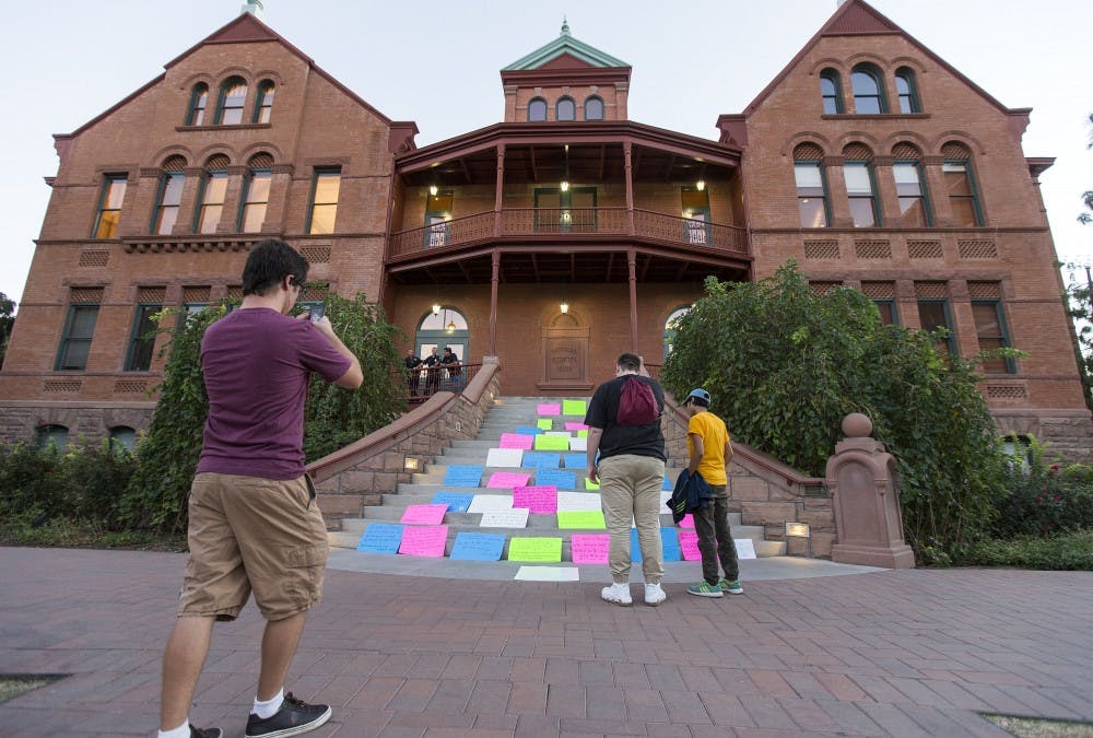 Students take photos of a protest against the outcome of the presidential election that was set up on the steps of the Old Main building on Thursday, Nov. 10, 2016. 