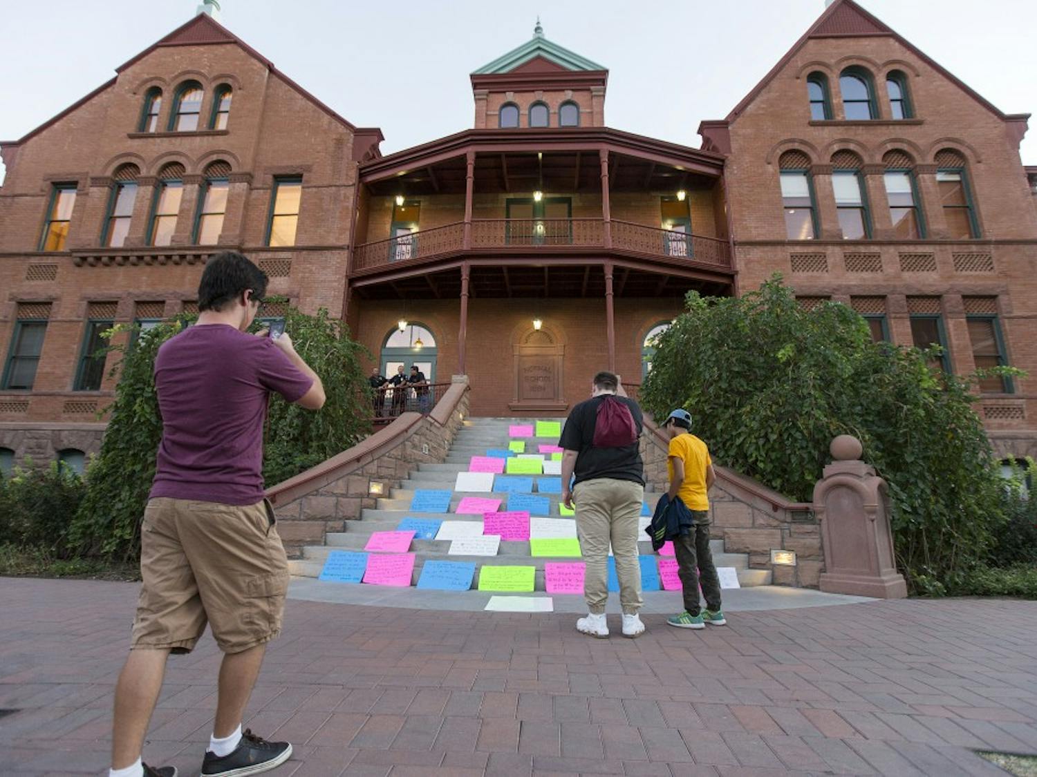 Students take photos of a protest against the outcome of the presidential election that was set up on the steps of the Old Main building on Thursday, Nov. 10, 2016. 