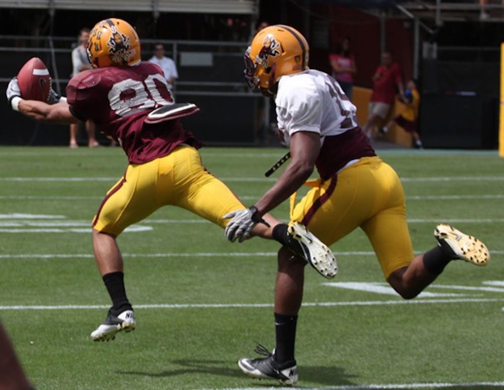 Offense rolls: ASU redshirt sophomore J. J. Holliday makes a grab near the sideline with redshirt sophomore Osahon Irabor defending. The Sun Devil offense controlled the spring game from the start, racking up over 600 yards. (Photo by Beth Easterbrook)
