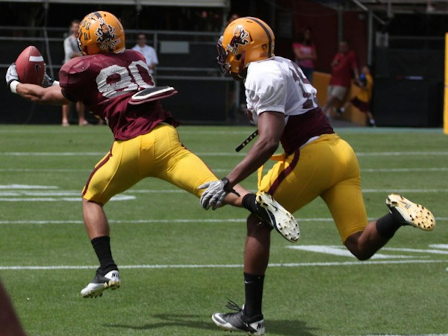 Offense rolls: ASU redshirt sophomore J. J. Holliday makes a grab near the sideline with redshirt sophomore Osahon Irabor defending. The Sun Devil offense controlled the spring game from the start, racking up over 600 yards. (Photo by Beth Easterbrook)