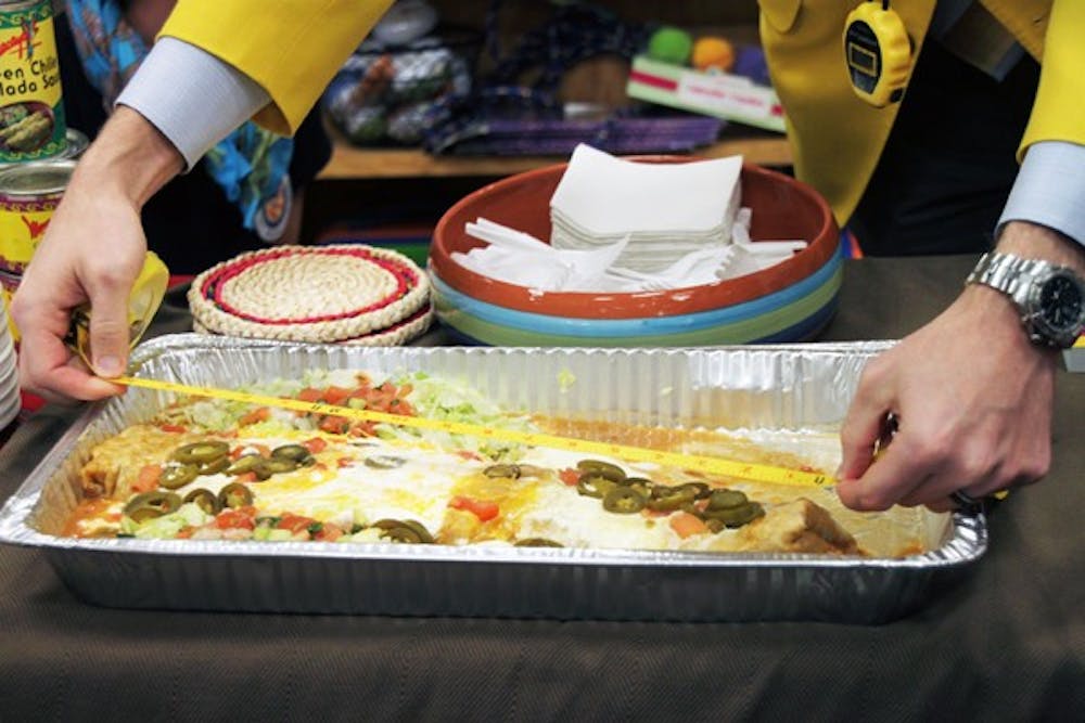 Dan Rollman and Corey Henderson, founders of World Record Setters, helped set a world record for the most people to share a single chimichanga at Changing Hands Bookstore Thursday night. The chimichanga measured in around 17" long and was made at Macayo's. (Photo by Rosie Gochnour)