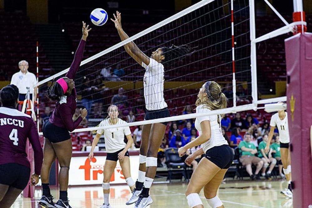 Junior middle blocker Mercedes Binns makes blocks an attack against North Carolina Central University on Saturday, Sept. 20, 2014 at Wells Fargo Arena in Tempe. The Sun Devils swept the Eagles 3-0. (Photo by Ben Moffat)