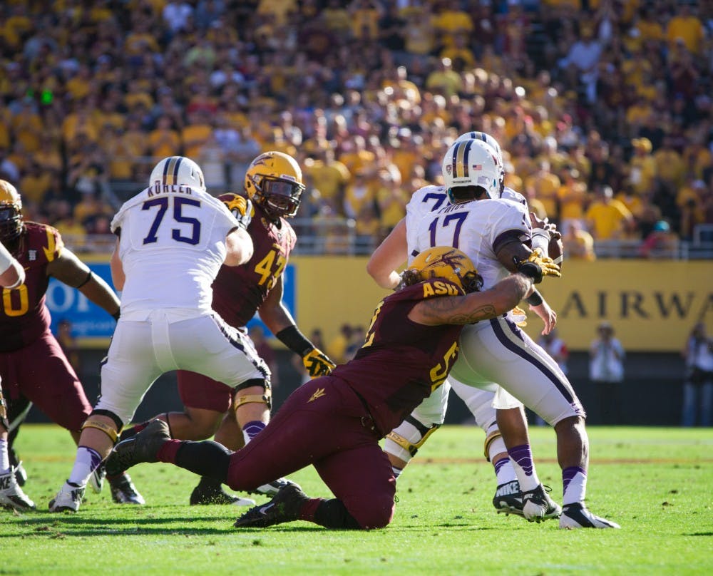 Redshirt junior Carl Bradford sacks senior quarterback Keith Price during ASU's homecoming game in Tempe. ASU defeated the Huskies 53-24. (Photo by Vince Dwyer) 