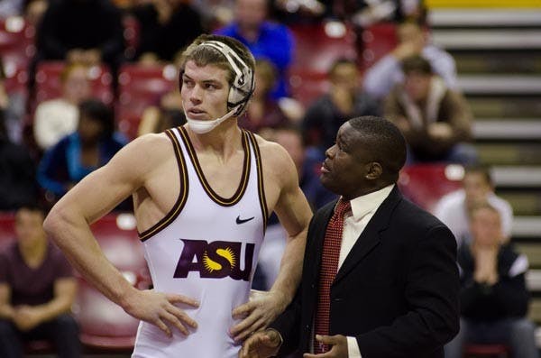 Teaching time: ASU coach Shawn Charles talks strategy with junior Jake Meredith during a dual earlier this season. The wrestling team competed in four matches on Saturday, losing three of them. Photo by Aaron Lavinsky.