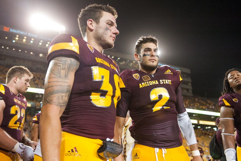 Redshirt senior safety Jordan Simone (38) and redshirt senior quarterback Mike Bercovici (2) celebrate after defeating Cal Poly 35-21 on Saturday, Sept. 12, 2015, at Sun Devil Stadium in Tempe.