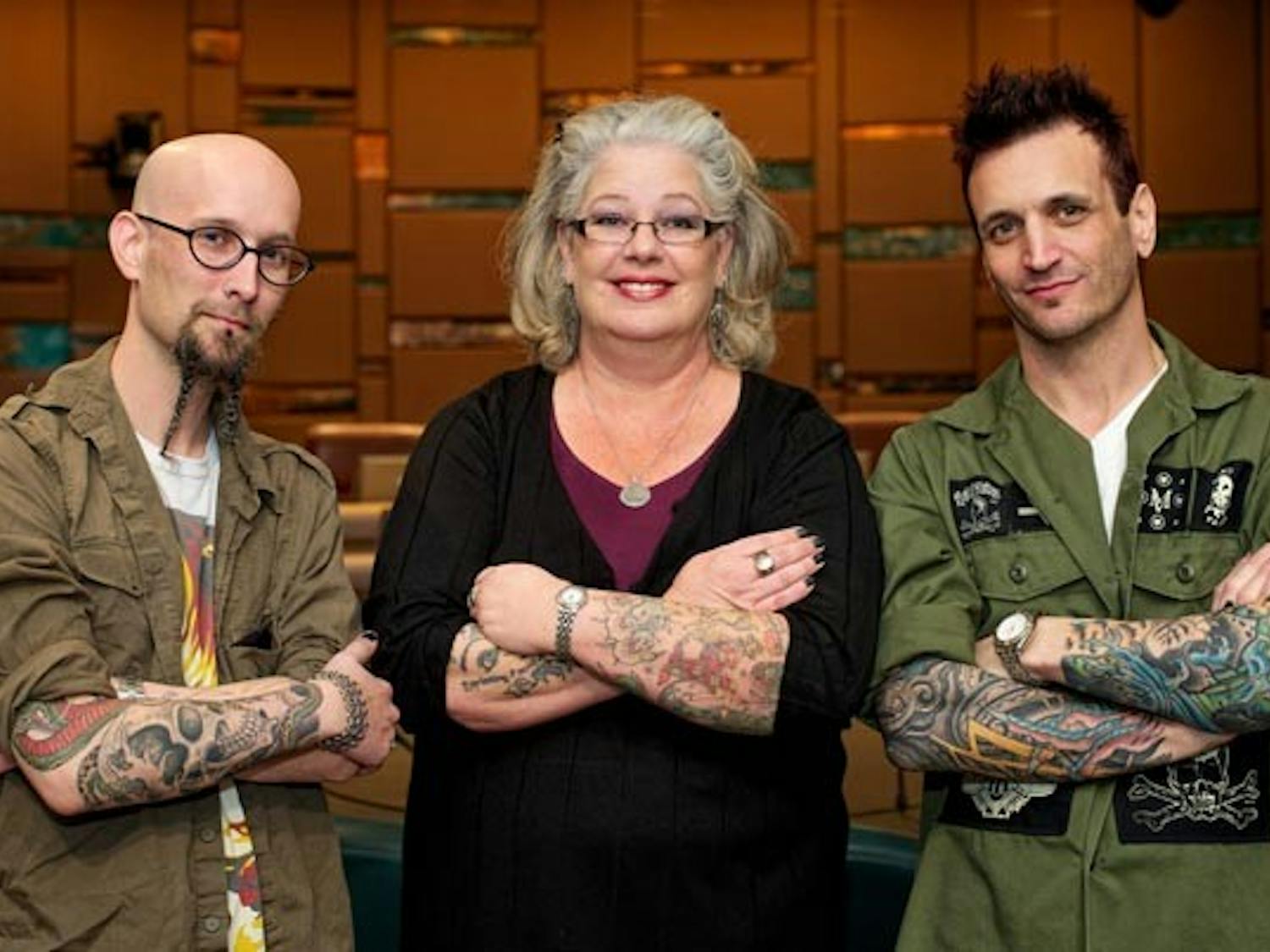 SELF EXPRESSION: Manger Chris Parrish, left, Jane Adler and owner Mark Walters of Living Canvas Tattoos proudly display their work in the Tempe City Council Chambers, after hosting a public forum on tattoo work on Wednesday. (Photo by Michael Arellano)