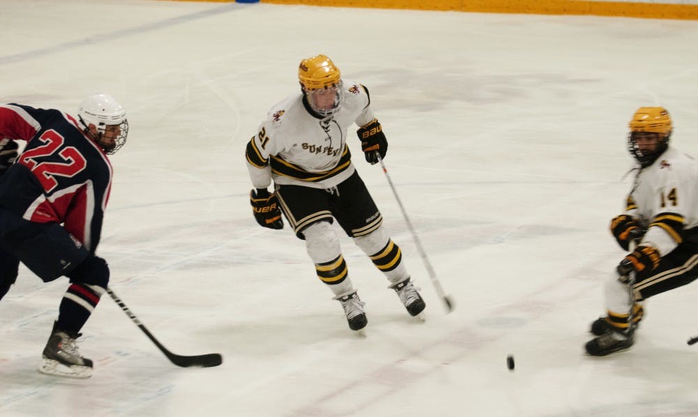 Defenseman Ryan Clark and forward Faiz Khan try to regain a loose puck against UA on Feb. 2. The ASU club hockey team looks to finish off their perfect record against UA this weekend.
(Photo by Molly J. Smith)