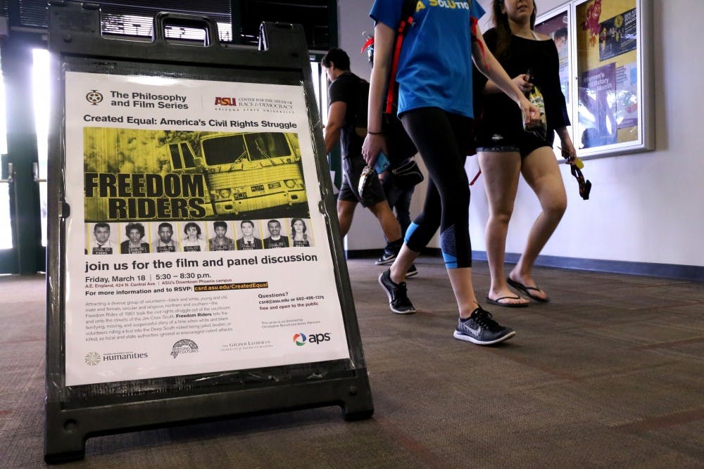 Students walk past a sign on Wednesday, March 16, 2016, in the University Center building advertising 'Freedom Riders' as the next film in the series of Created Equal: America's Civil Rights Struggle.