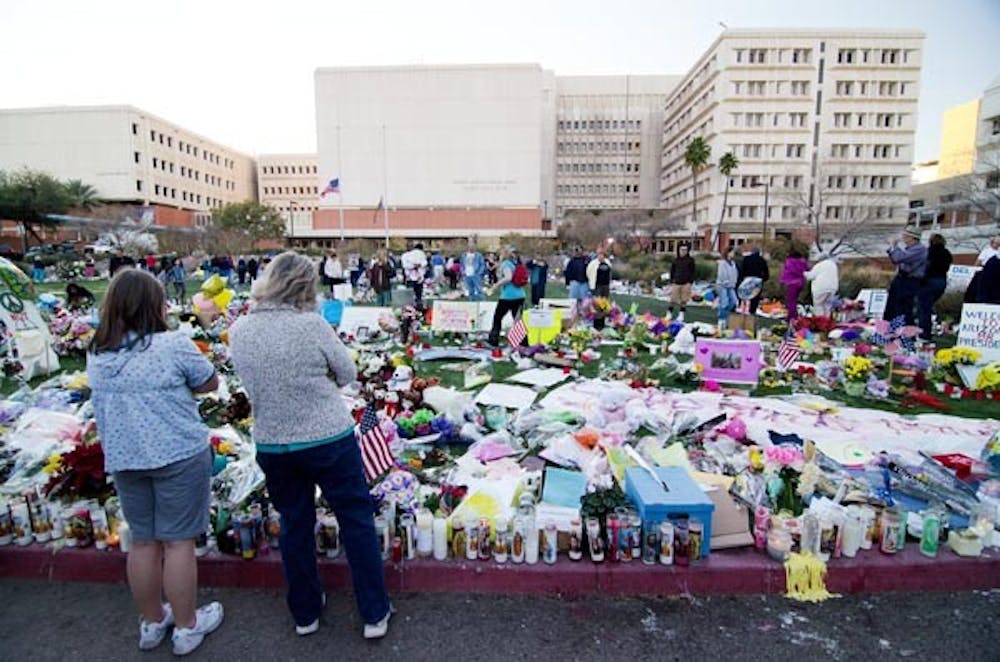 EMERBERANCE: People from across the country gather at a makeshift memorial outside the University Medical Center in Tucson, Ariz., to pay their respects to those killed and injured during the Jan. 8 shooting. Photo by Aaron Lavinsky