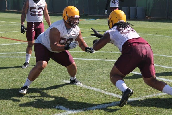 Redshirt junior defensive lineman Mo Latu (left) shoots his hands up to attack junior defensive lineman Jaxon Hood during a practice on April 16, 2013. (Photo by Edmund Hubbard)