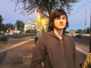 Ben Cooper, freshman philosophy major at ASU, waits for the light rail after leaving a protest on Trump's ban on refugees at Sky Harbor International Airport on January 29, 2017.&nbsp;