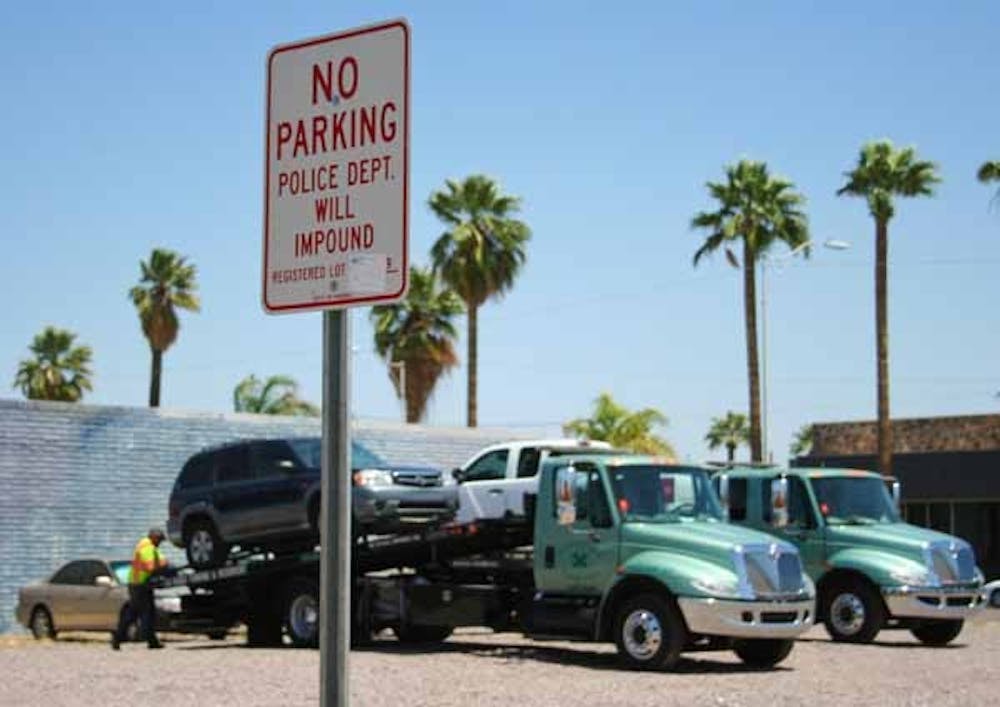 NO PARKING: Nearly 70 vehicles were towed from a private dirt lot north of ASU's Downtown campus on Monday and Tuesday.  Many of the vehicles belong to students who park there on a daily basis. (Photo by Lisa Bartoli)