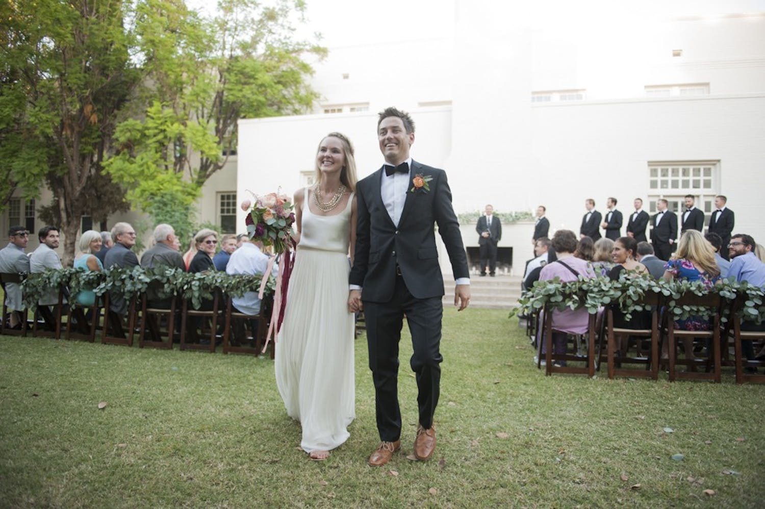 ASU alumni Heather Hague (left) and Tyler Anderson walk down the aisle after their marriage ceremony on Saturday, Oct. 24, 2015, at the Secret Garden on the Tempe campus.