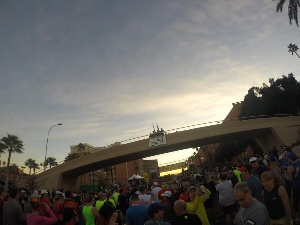 The color guard hoists the American flag over the University Bridge on University Drive prior to the start of the P.F. Chang's Arizona Rock N' Roll Half Marathon on Sunday, Jan. 18, 2015. (Photo by Stefan Modrich)