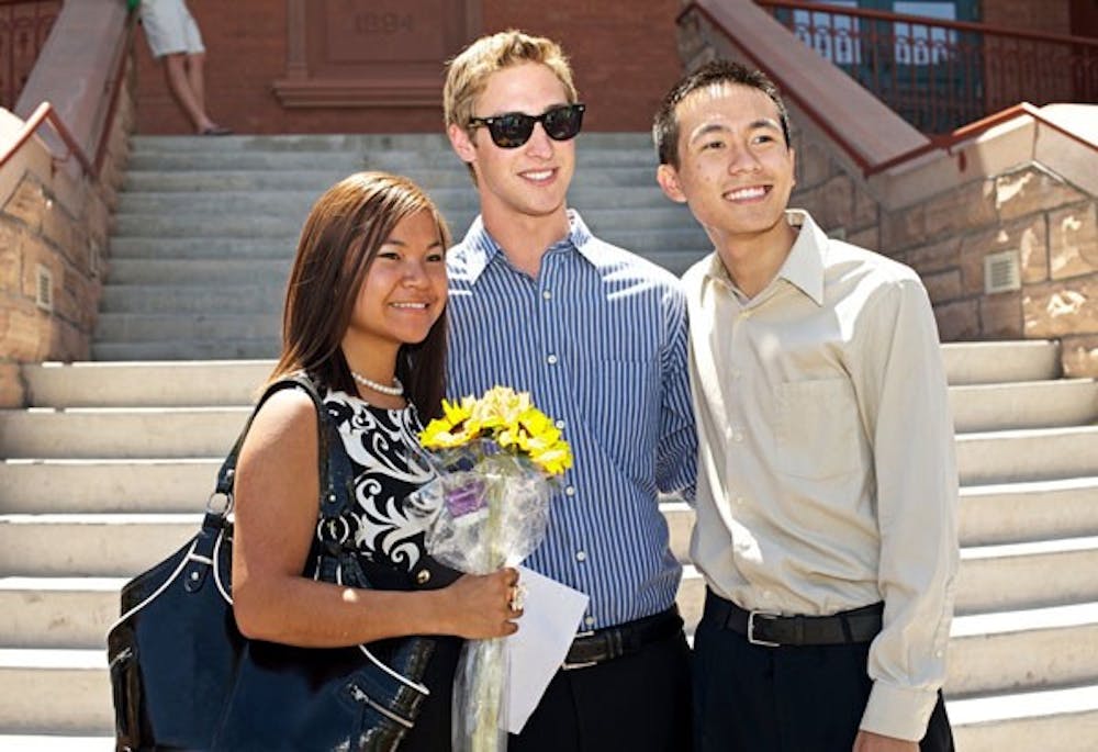 RUNOFF RESULTS: Jacob Goulding, center, and running-mates Michael Wong and Tina Mounlavongsy celebrate the results of their election in the USG Presidential runoff election on the steps of Old Main. Goulding earned 57.9% of the 3,448 votes cast, with Brendan Corrigan garnering 41.1%. (Photo by Michael Arellano)