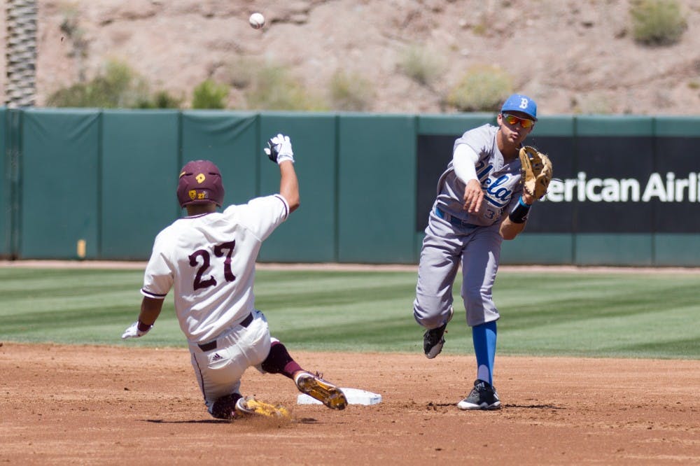 UCLA junior infielder Chase  Strumpf (33) turns the double play as ASU freshman infielder Lyle Lin (27) slides in to second during game three of a baseball series against the UCLA Bruins at Phoenix Municipal Stadium in Phoenix on April 2, 2017.