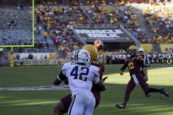 Senior Chris Young shakes the hand of Washington sophomore Taniela Tupou after the game. The Sun Devils won 53-24 in Tempe. (Photo by Diana Lustig)