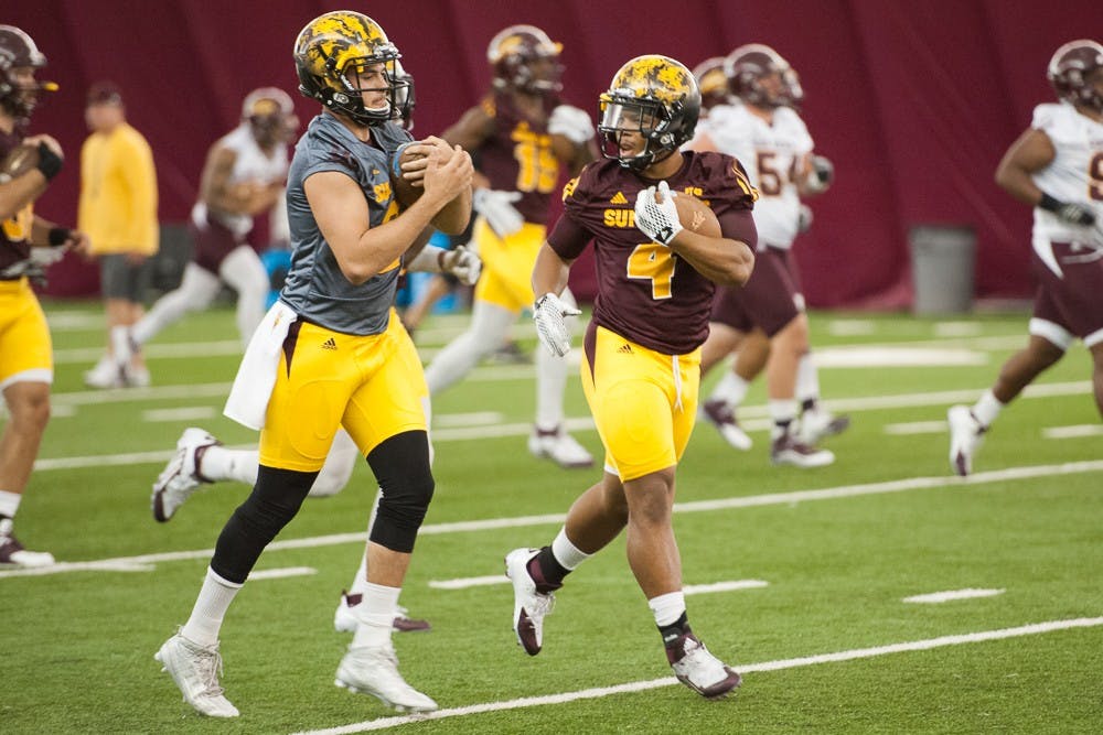 Redshirt senior quarterback Mike Bercovici (left) and sophomore running back Demario Richard run a drill during ASU football practice on Thursday, Aug. 6, 2015, at the Verde Dickey Dome in Tempe.