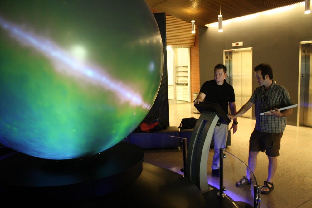 Doctor Danny Jacobs, a post doctorate in the School of Earth and Space Exploration and G. Paul Hudak, content manager of the gallery of scientific exploration, observe the low-frequency radio sky image. This image illustrates everything we know about the low-frequency radio sky, according to Dr. Jacobs. (Photo by Hector Salas Almeida)