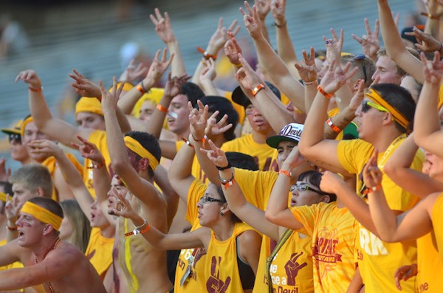 FAN FAVORITES: ASU supporters in the student section raise their pitchforks and cheer during Thursday night's football game against UC Davis.  The Sun Devils won their first game of the season 48-14. (Photo by Aaron Lavinsky)