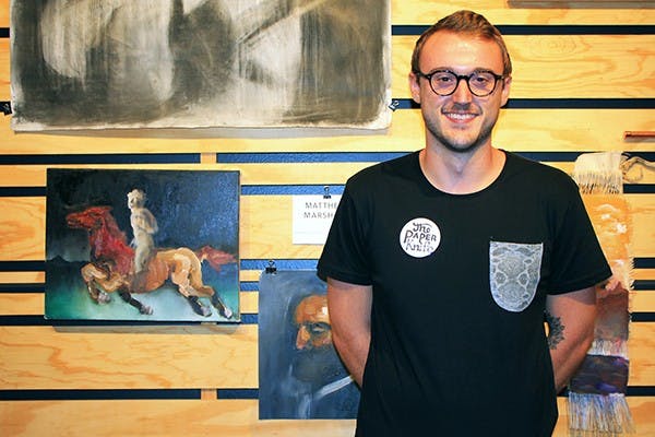 Matthew Marshall with his artwork at Cartel Coffee Lab during the release of the second volume of TPK’s print publication on Friday, Sept. 5, 2014. (Photo by Shiva Balasubramanian)