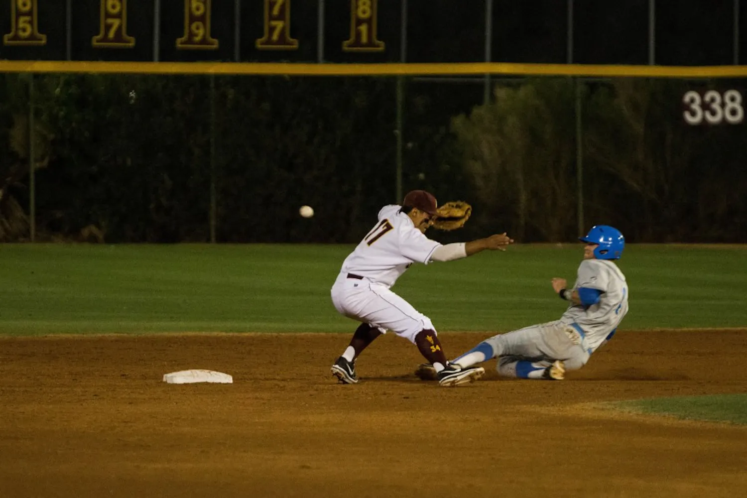 Sophomore Drew Stankiewicz attempts to field a ground ball at second base as a runner from UCLA slides into second base. Stankiewicz plans to spend his summer at a minor league camp. (Photo by Dominic Valente)