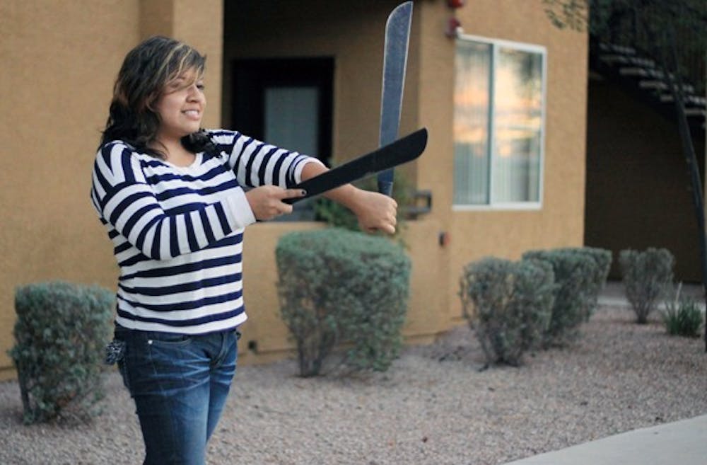 DANCING WITH MACHETES: Cell genetics and developmental biology senior Diana Alarcon practices stepping with machetes. It is a tradition for the members of the Lambda Theta Nu sorority to learn stepping with machetes. (Photo by Lillian Reid)