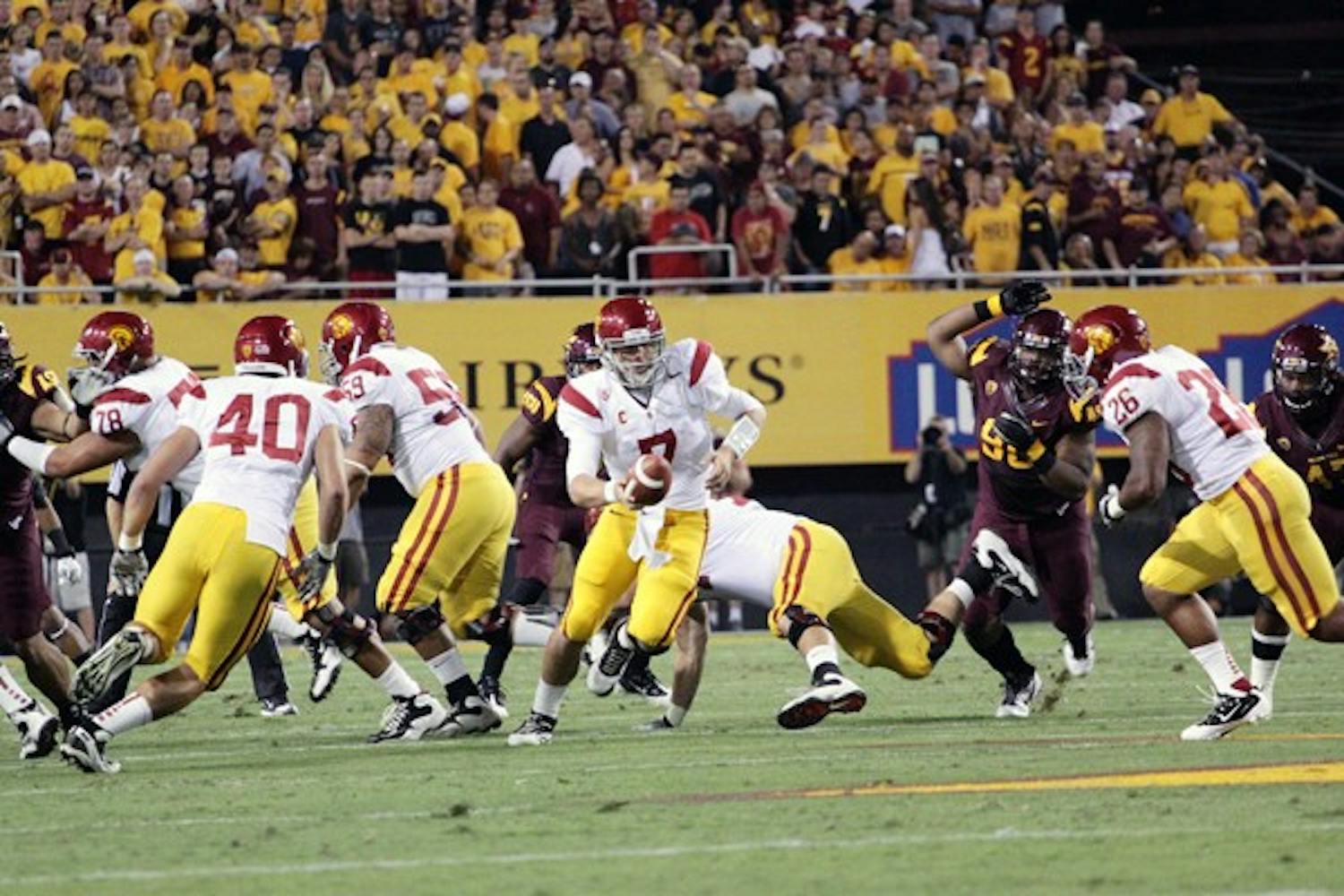 DOWN TO MISTAKES: USC junior quarterback Matt Barkley extends for a handoff to redshirt senior Marc Tyler in the Trojan’s 43-22 loss to ASU. Crucial penalties and untimely turnovers contributed to the end of USC’s 11-game winning streak against the Sun Devils. (Photo by Beth Easterbrook)
