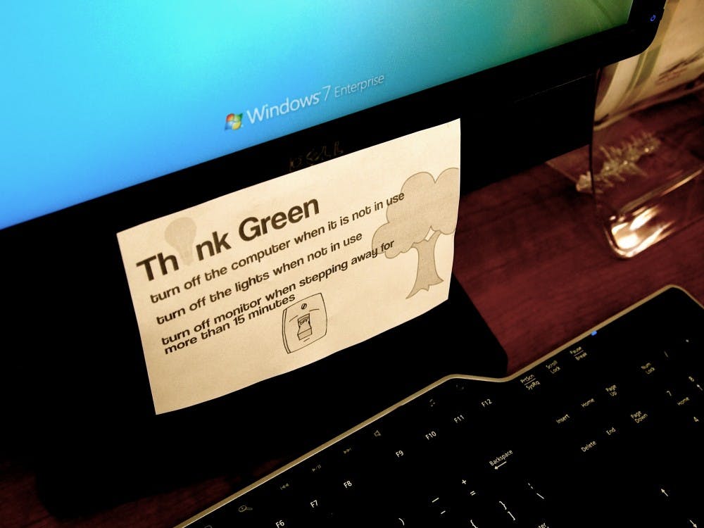 'Think Green' note cards posted on computer screens of the USGD office as well as light switches to ensure members try to reduce their electricity waste. (Kaitlyn Ahr/ The State Press)