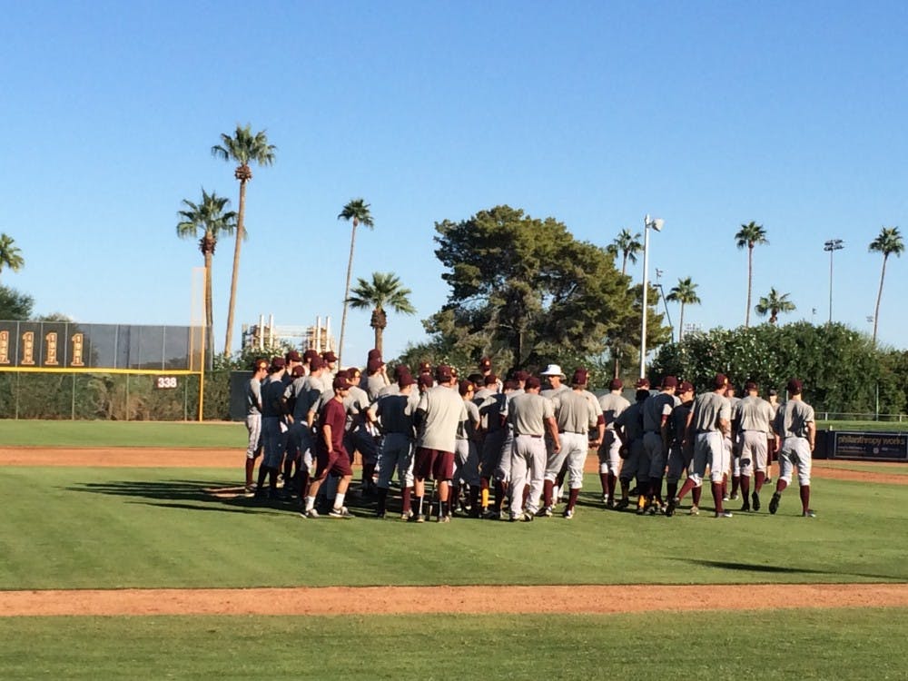 The ASU baseball team huddles around head coach Tracy Smith at the pitcher's mound at Packard Stadium during a break in Monday afternoon's practice. (Photo by Stefan Modrich)