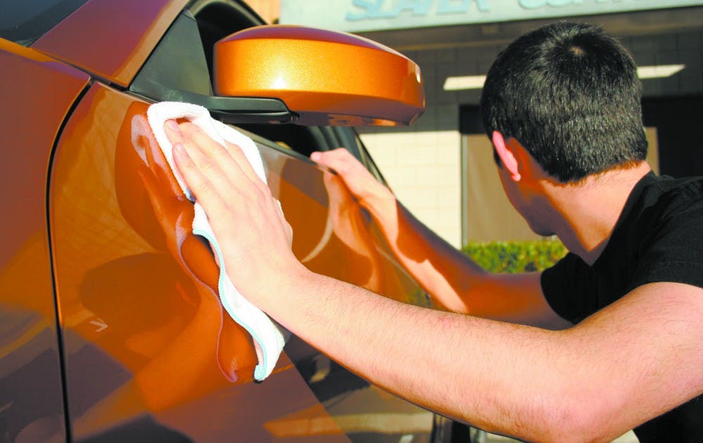 PASSION FOR THE INANIMATE: An ASU student carefully details his car on wednesday afternoon near the Tempe campus. A recent study by researchers at ASU revealed that people can have strong feelings of attachment and  love for material objects and not just for other people. (Photo by Lisa Bartoli)