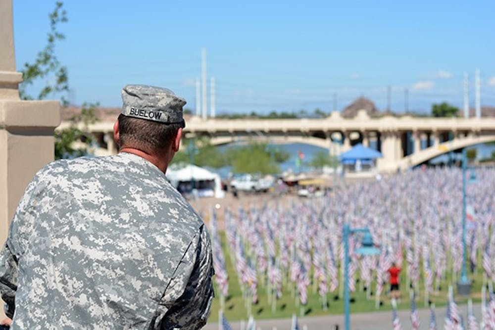 US Army Sergeant Major Aaron Buelow looks down at the thousands of flags scattered across Tempe Beach Park in Tempe, AZ on Thursday, Sept. 11, 2014. (Photo by Jonathan Williams)