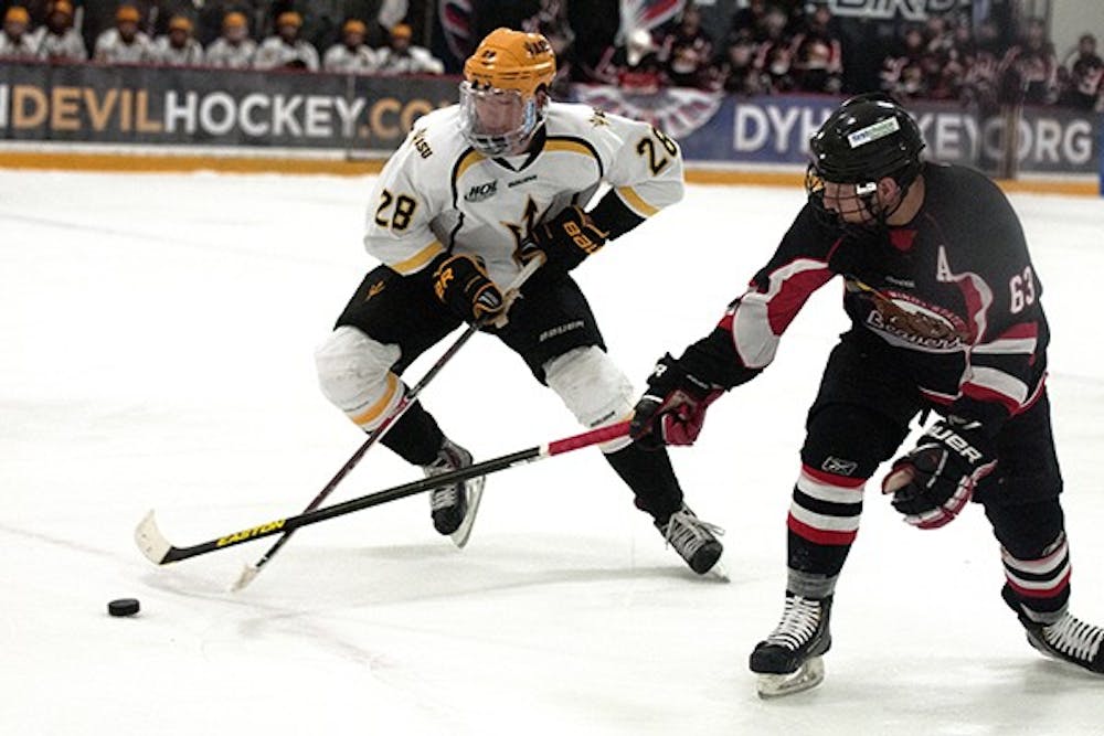  Mike Cummings wrestles with Minot State opposition for the puck. Cummings had a hat trick as he led ASU to a 8-5 win over Central Oklahoma on Jan. 10. (Photo by Mario Mendez)