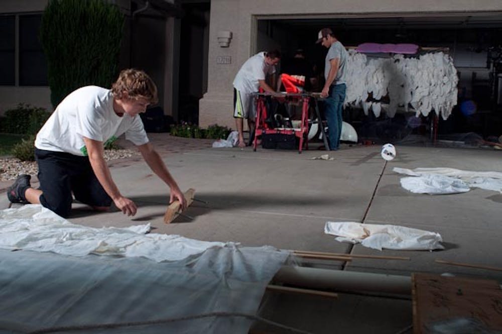 Cameron Alder, Brett Hileman and Blaine Coury work on their Redbull Flugtag craft "Unexpected Delivery" for the Flugtag competiton in Long Beach, Ca. this past Saturday. (Photo by Aaron Lavinsky)