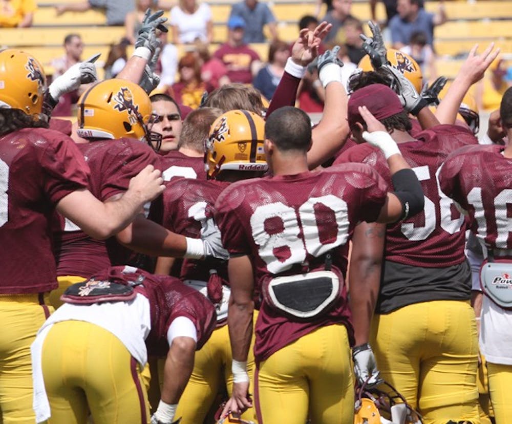 ALL TOGETHER: The ASU football team huddles and raises pitchfork signs after the spring game in April. The Sun Devils begin the inaugural Pac-12 season just outside the Top 25 in preseason polls. (Photo by Beth Easterbrook)