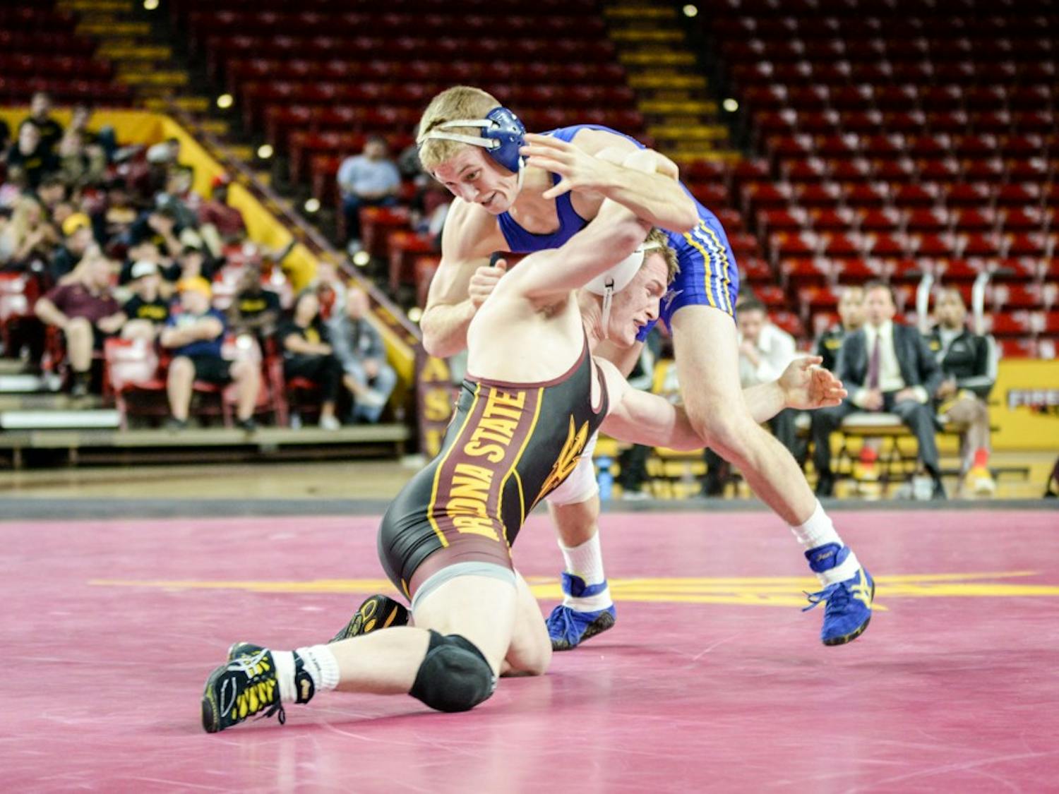 ASU sophomore Oliver Pierce sweeps the leg of CSU Bakersfield's Spencer Hill in their matchup on Sunday, Jan. 18, 2015, at Wells Fargo Arena in Tempe. Pierce won the match 5 – 4. The Sun Devils went on to win against the Roadrunners 31 – 6. (J. Bauer-Leffler/The State Press)