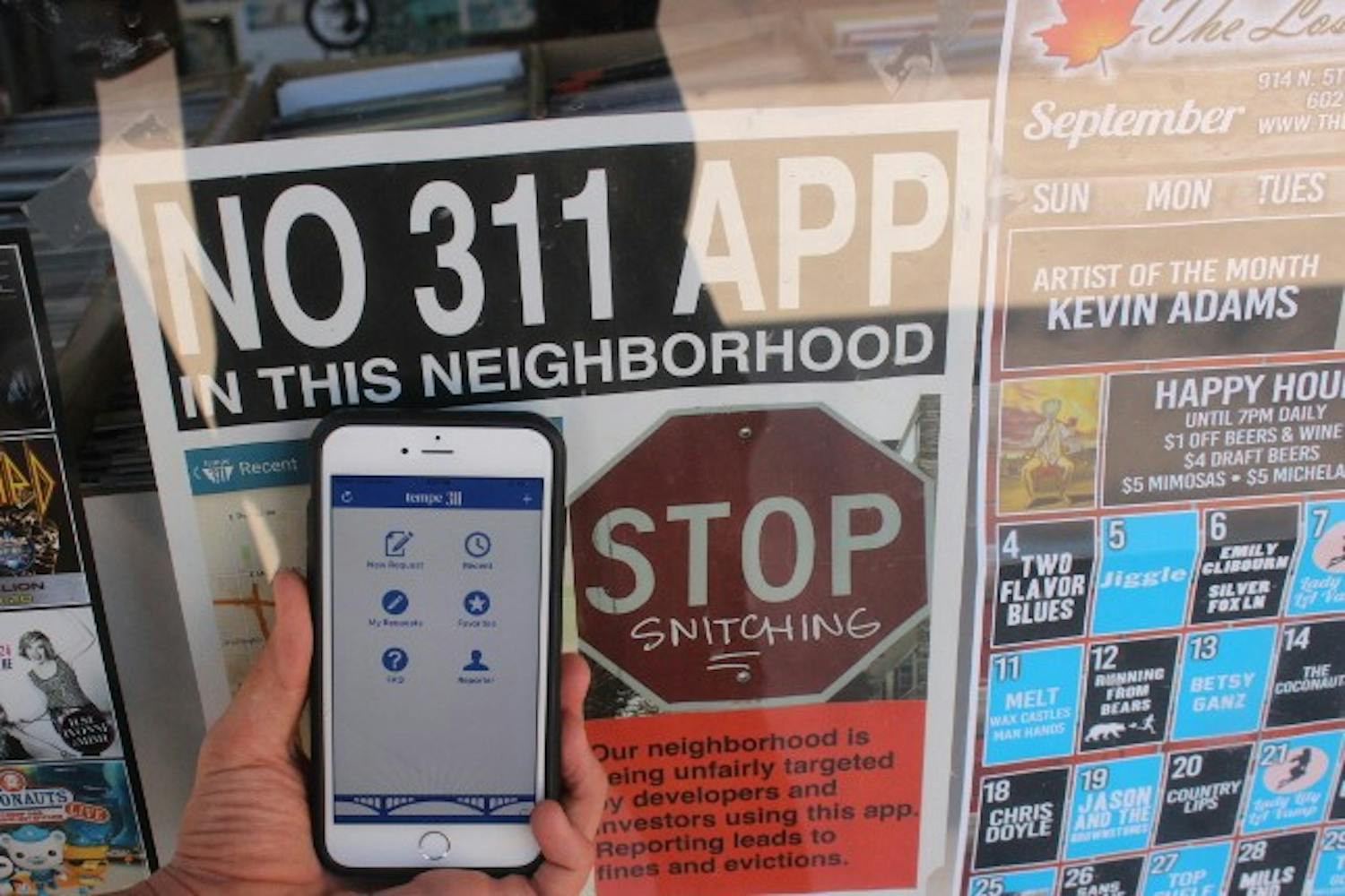 A sign, pictured on Sunday, Sept. 11, 2016, on the window of Ash Ave Comics & Book Store, located in Tempe, warns users of the Tempe 311 app they are not welcome in the neighborhood surrounding the store. 