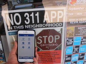 A sign, pictured on Sunday, Sept. 11, 2016, on the window of Ash Ave Comics & Book Store, located in Tempe, warns users of the Tempe 311 app they are not welcome in the neighborhood surrounding the store. 
