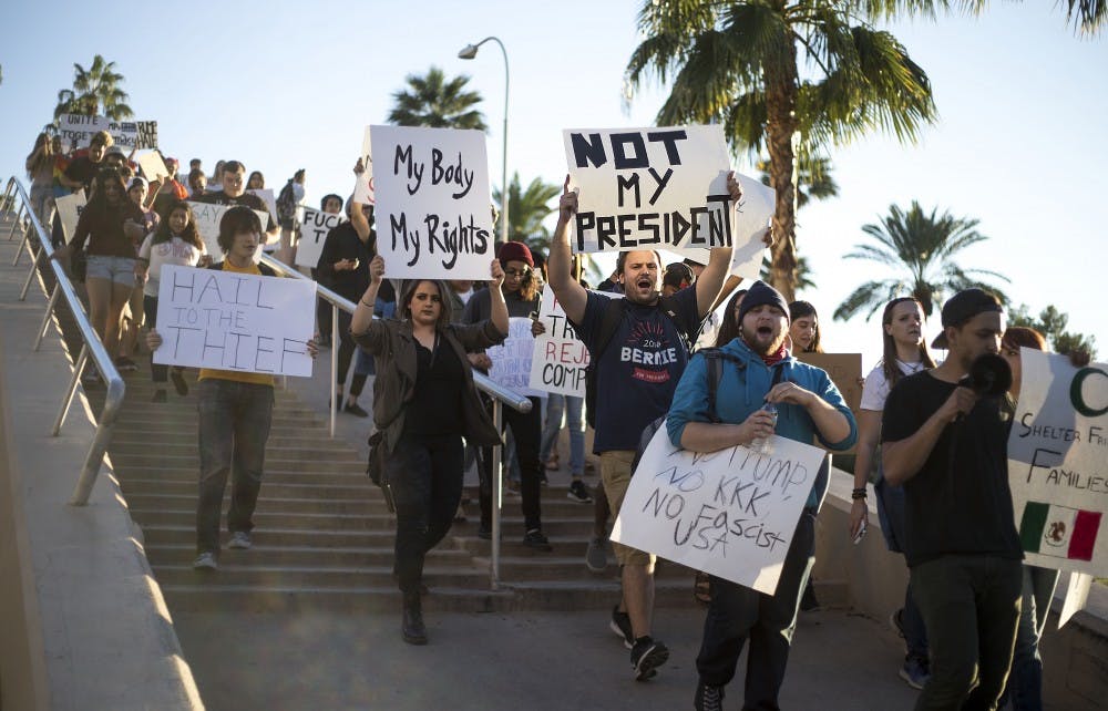 Protestors begin to march down the University Drive bridge during a protest of the 2016 presidential election results near the ASU Tempe campus on Friday, Nov. 11, 2016. 